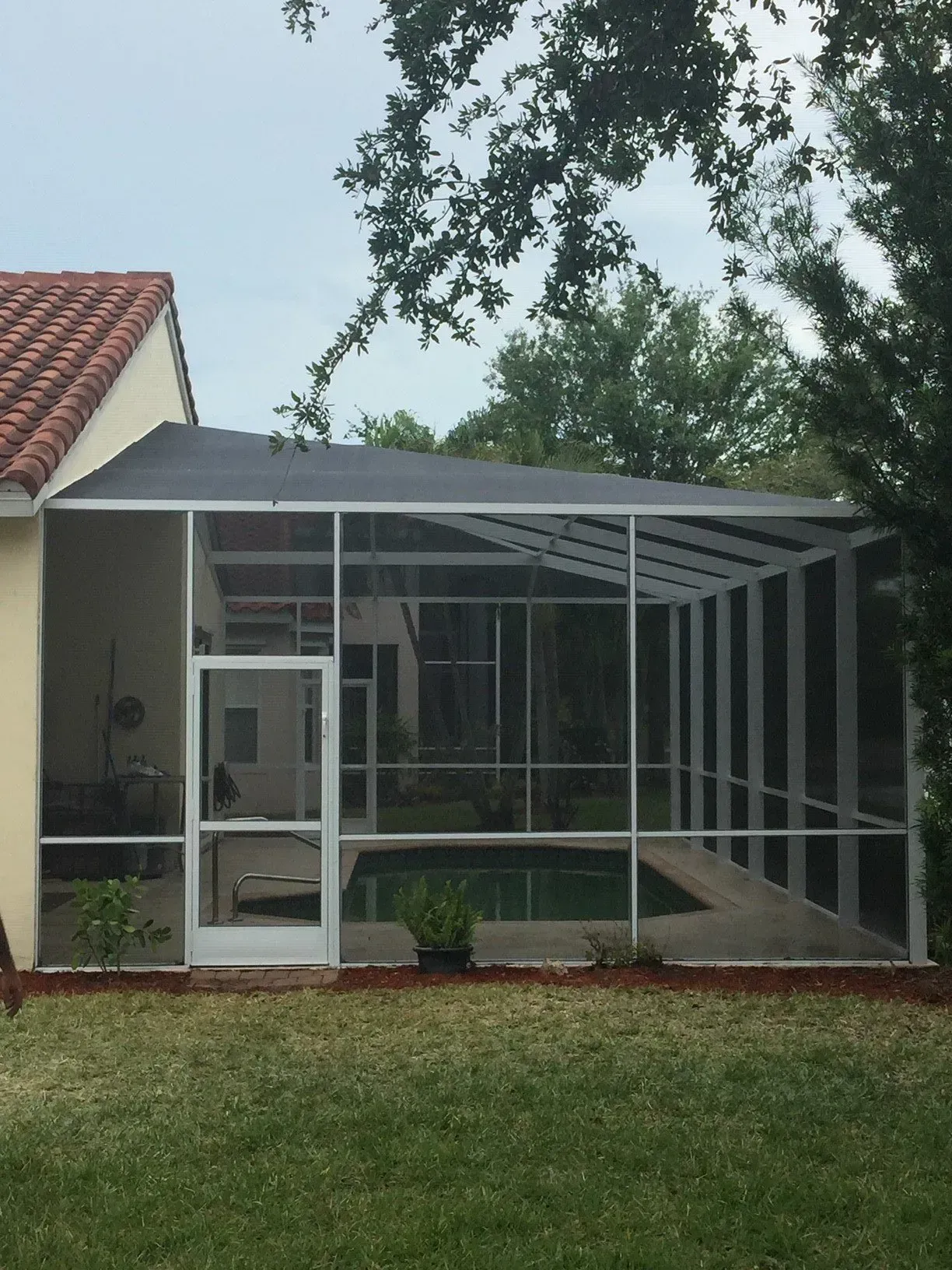 A screened in area with a pool in the backyard