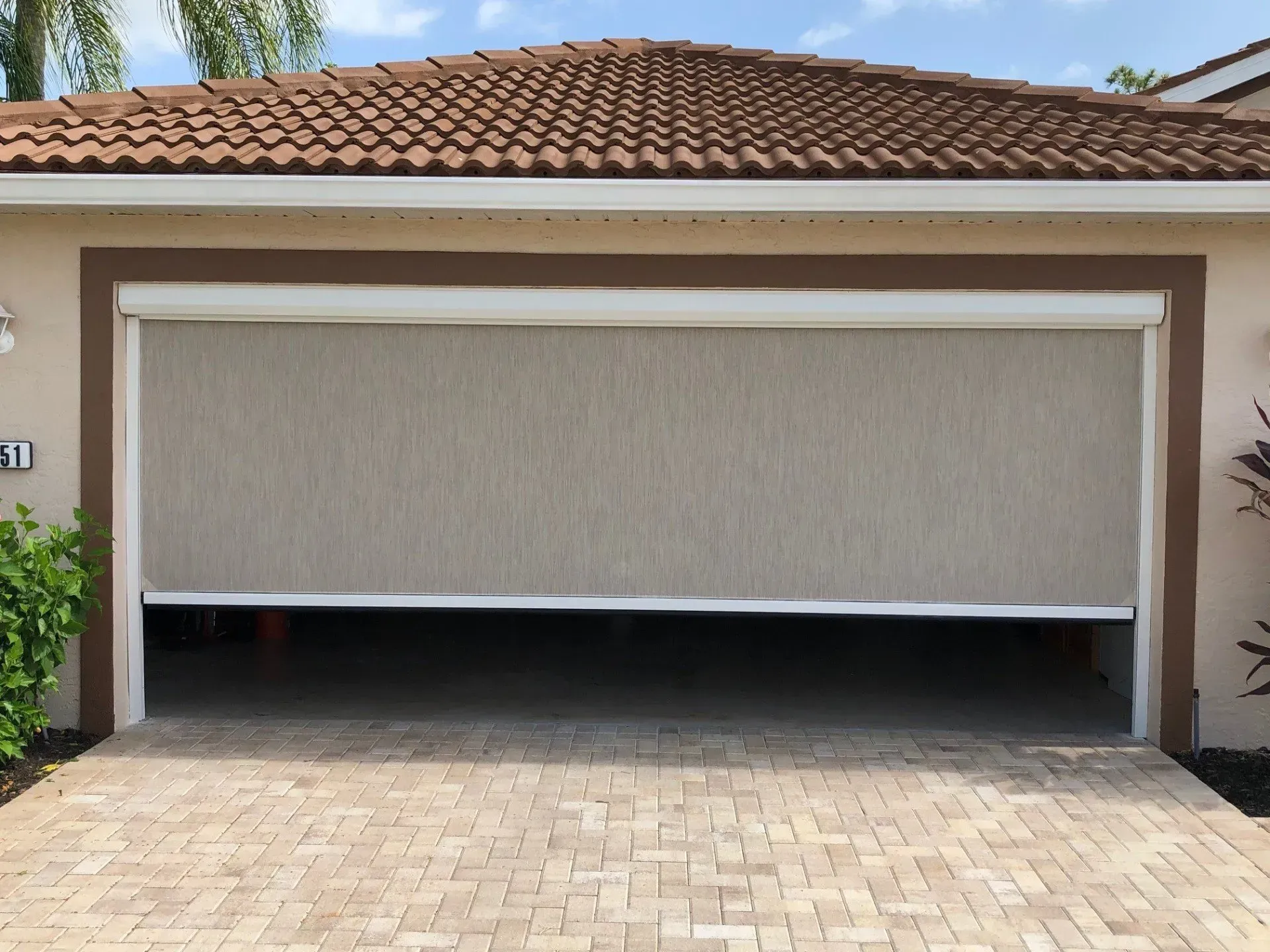 A garage door with a screen on it is open