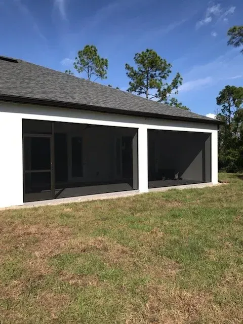 A house with a screened in porch in the backyard