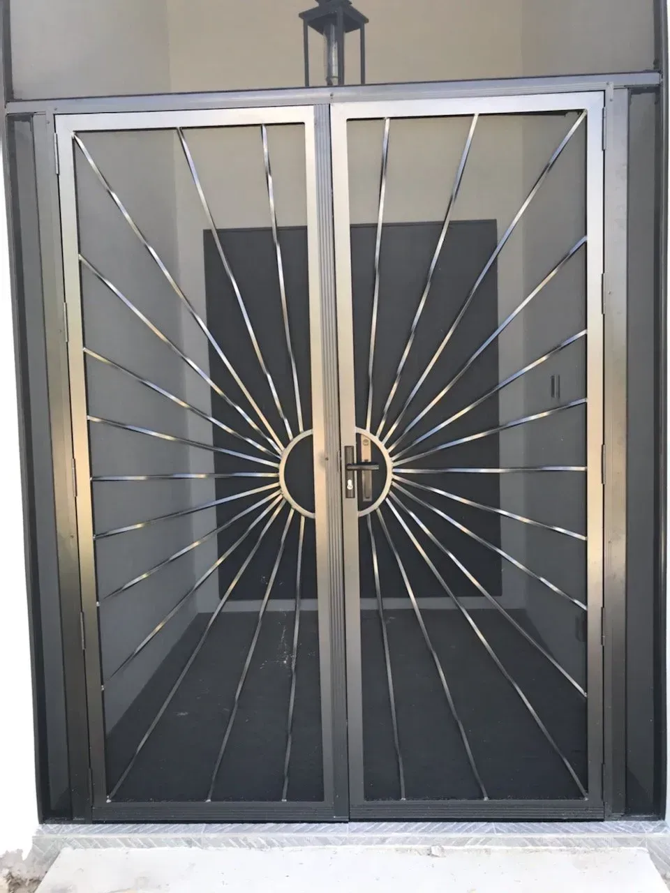 A stainless steel door with a sun design on it