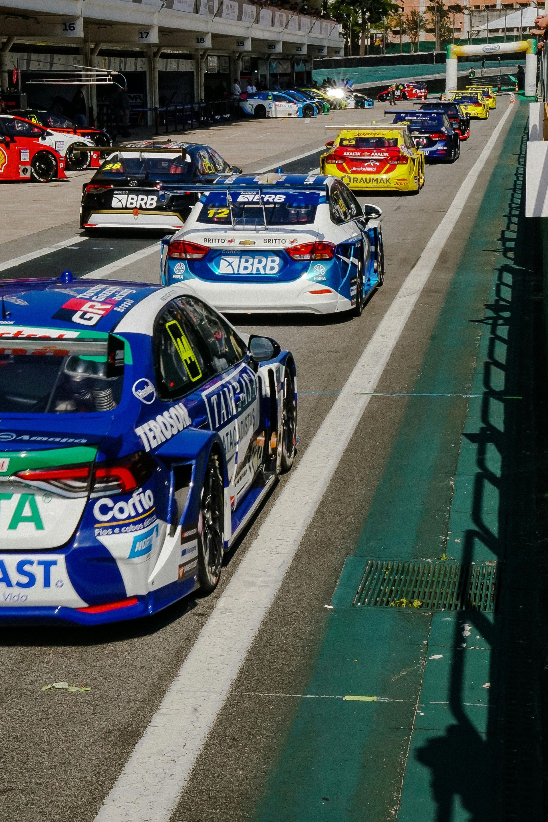 Race cars lined up on a track, various colors.