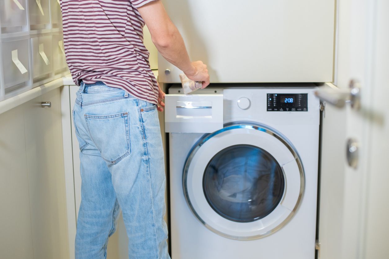 Man in front of Top Loader vs Front Loader Washing Machine