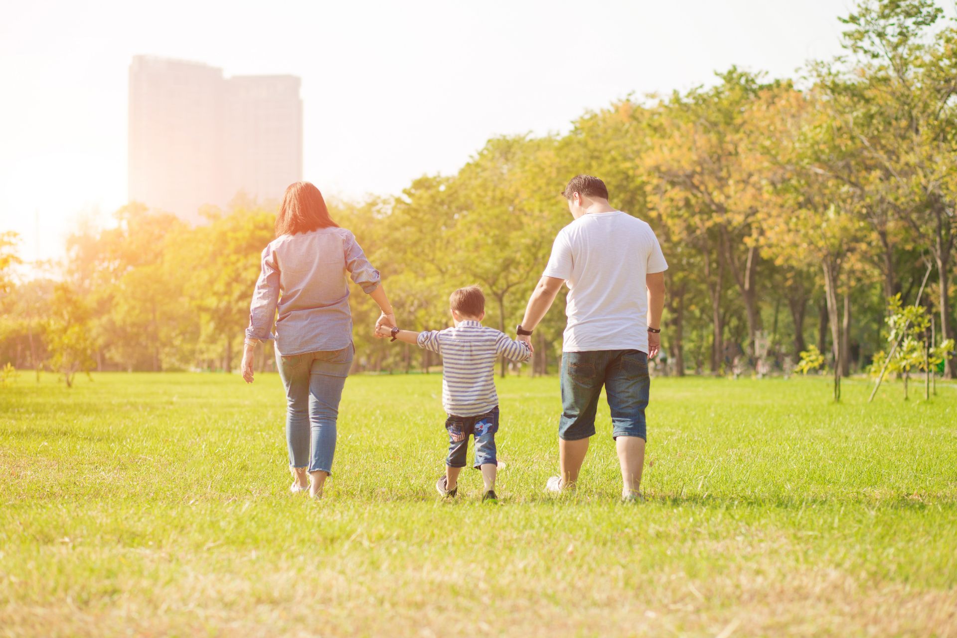 Family of three walking in the grass