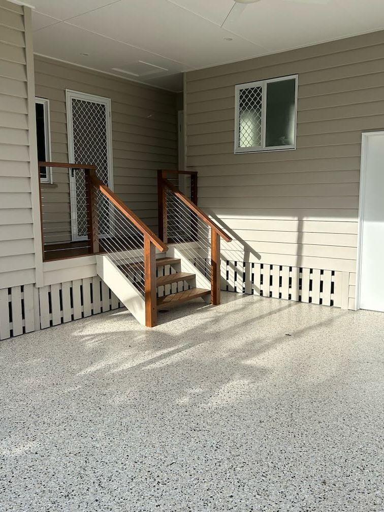 A garage with stairs leading up to a porch and a fence — Building Services in Rockhampton