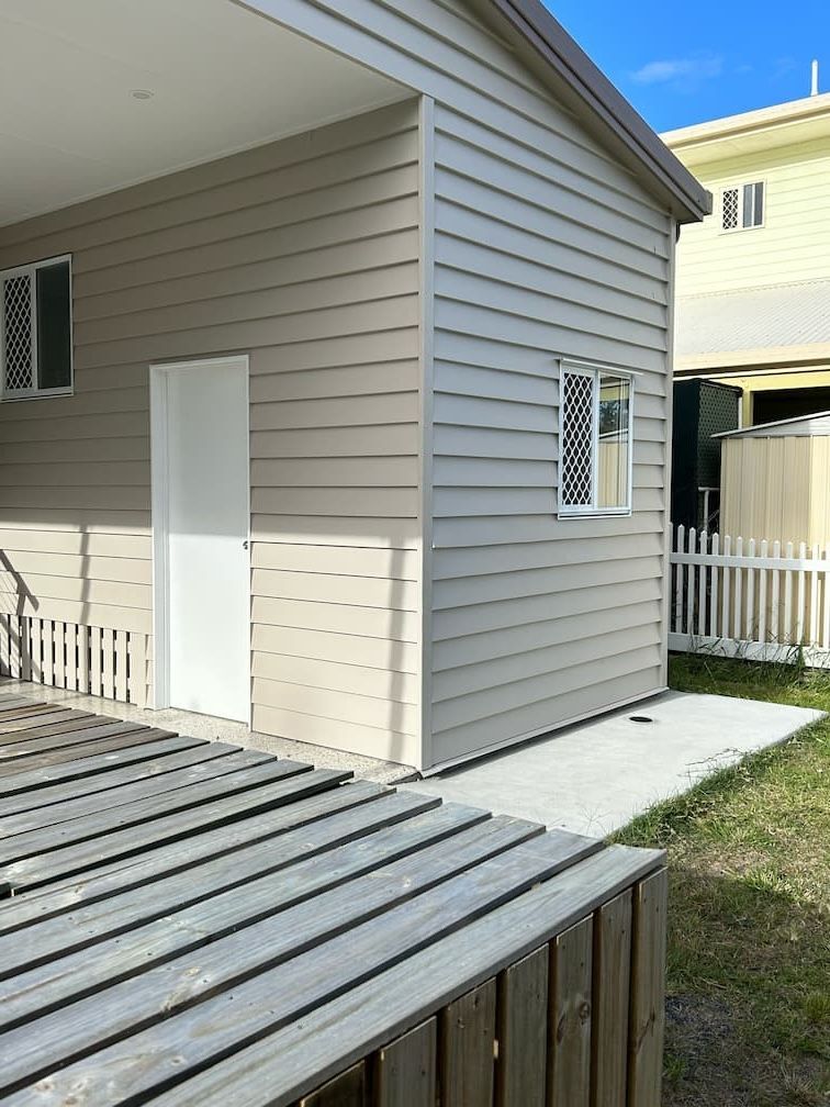 A small house with a wooden deck in front of it — Building Services in Rockhampton
