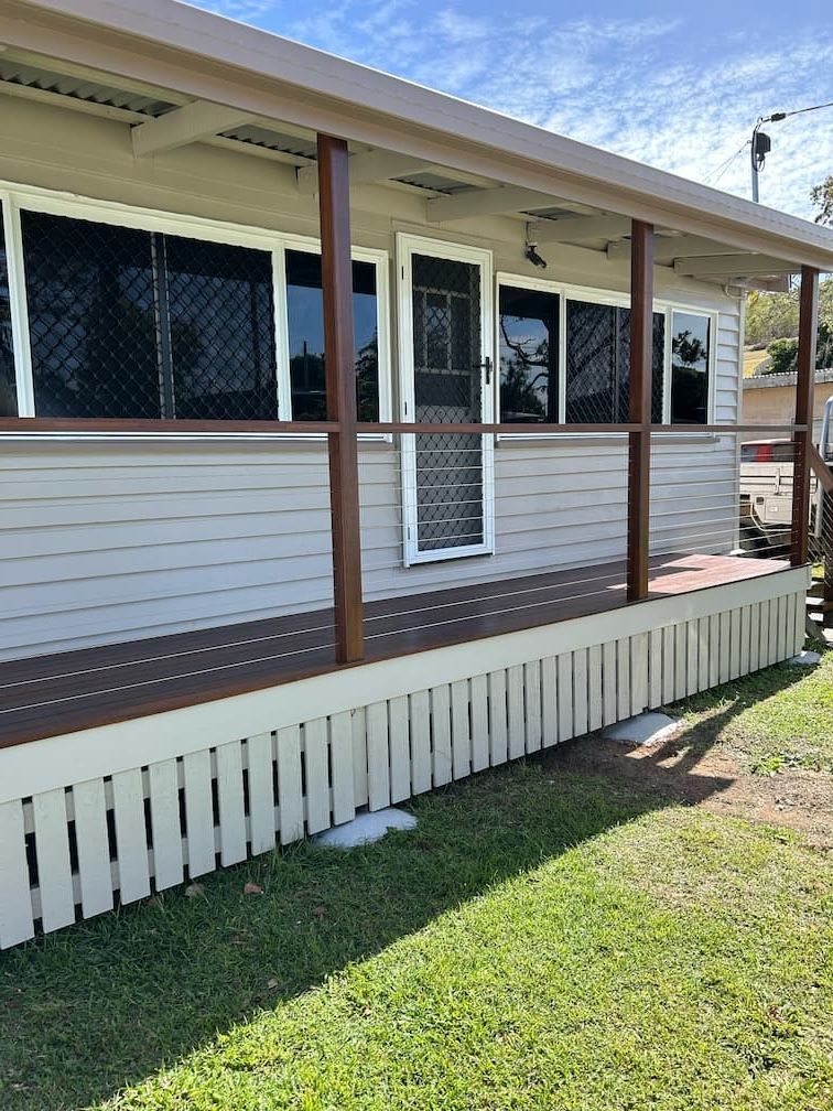 A house with a porch and a fence in front of it — Building Services in Rockhampton