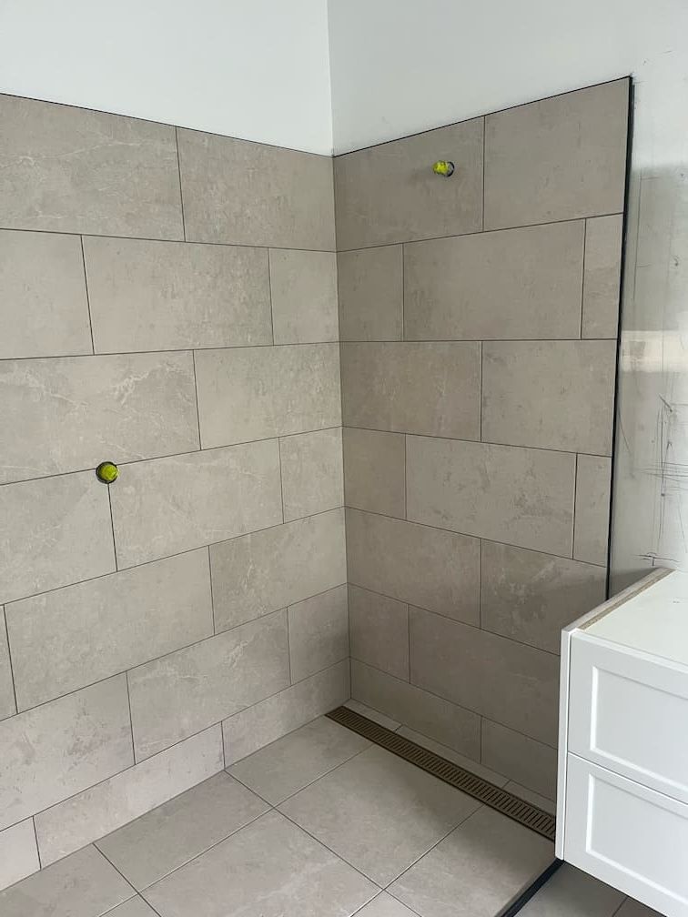 A bathroom with tiled walls and a white vanity — Building Services in Rockhampton