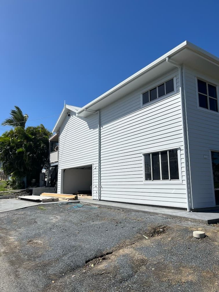 A large white house with a garage underneath it is being built — Building Services in Rockhampton