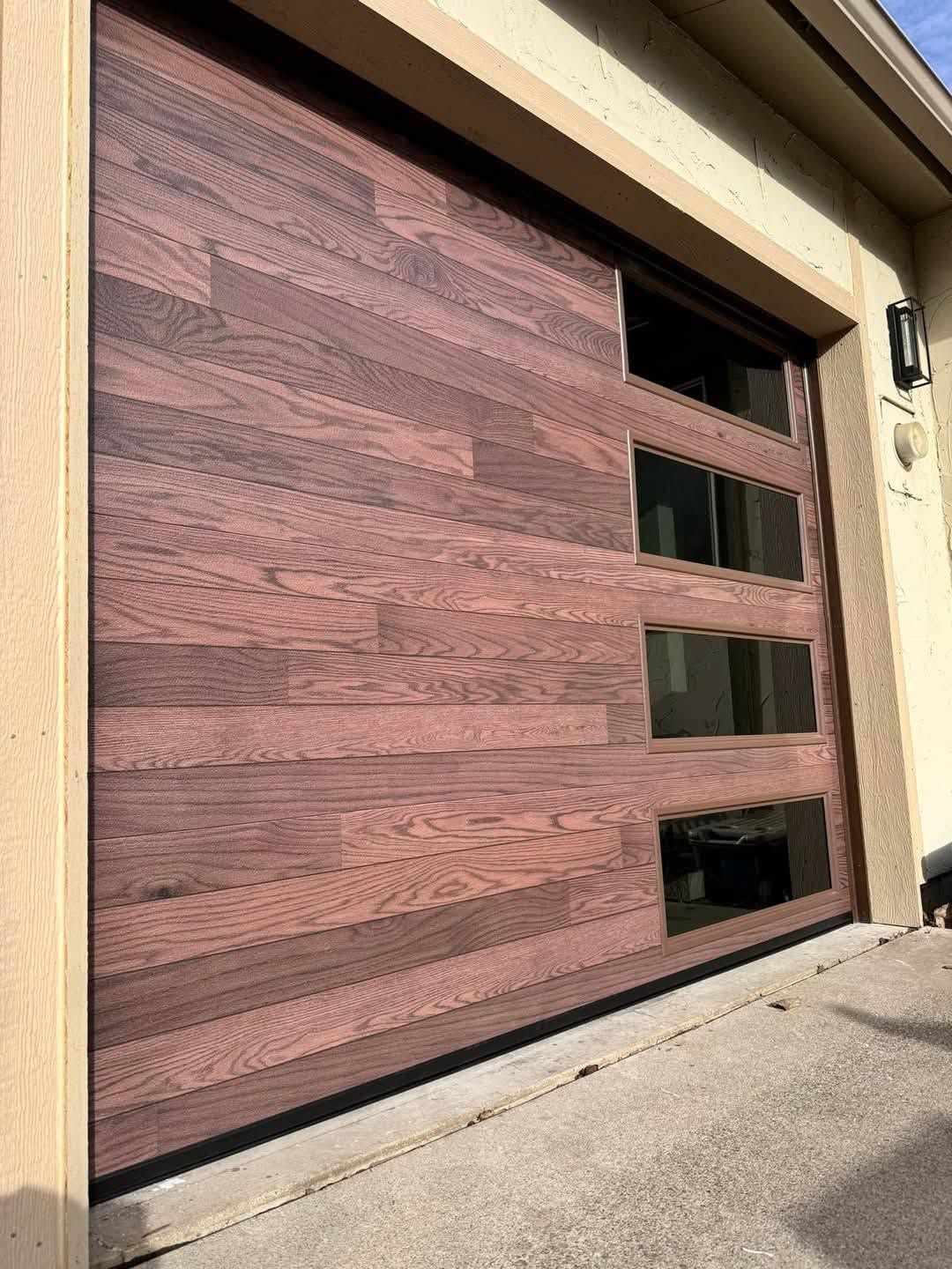 Wood-paneled garage door with three horizontal windows in a beige exterior wall