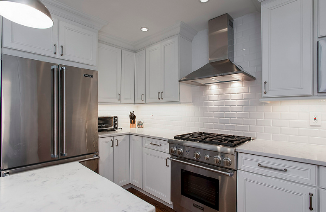 A kitchen with white cabinets and stainless steel appliances.