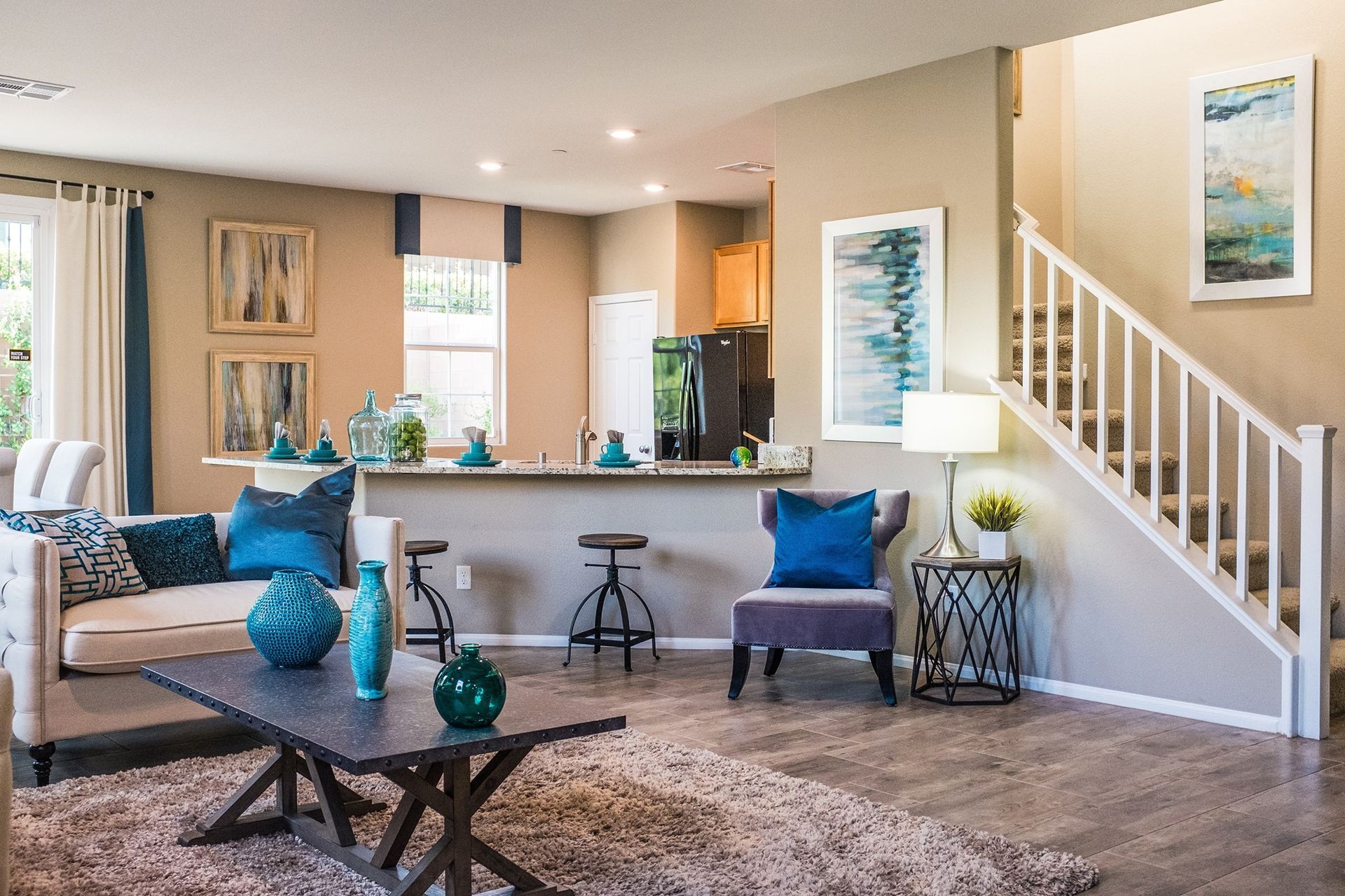 A living room with a couch , coffee table , chairs and stairs.