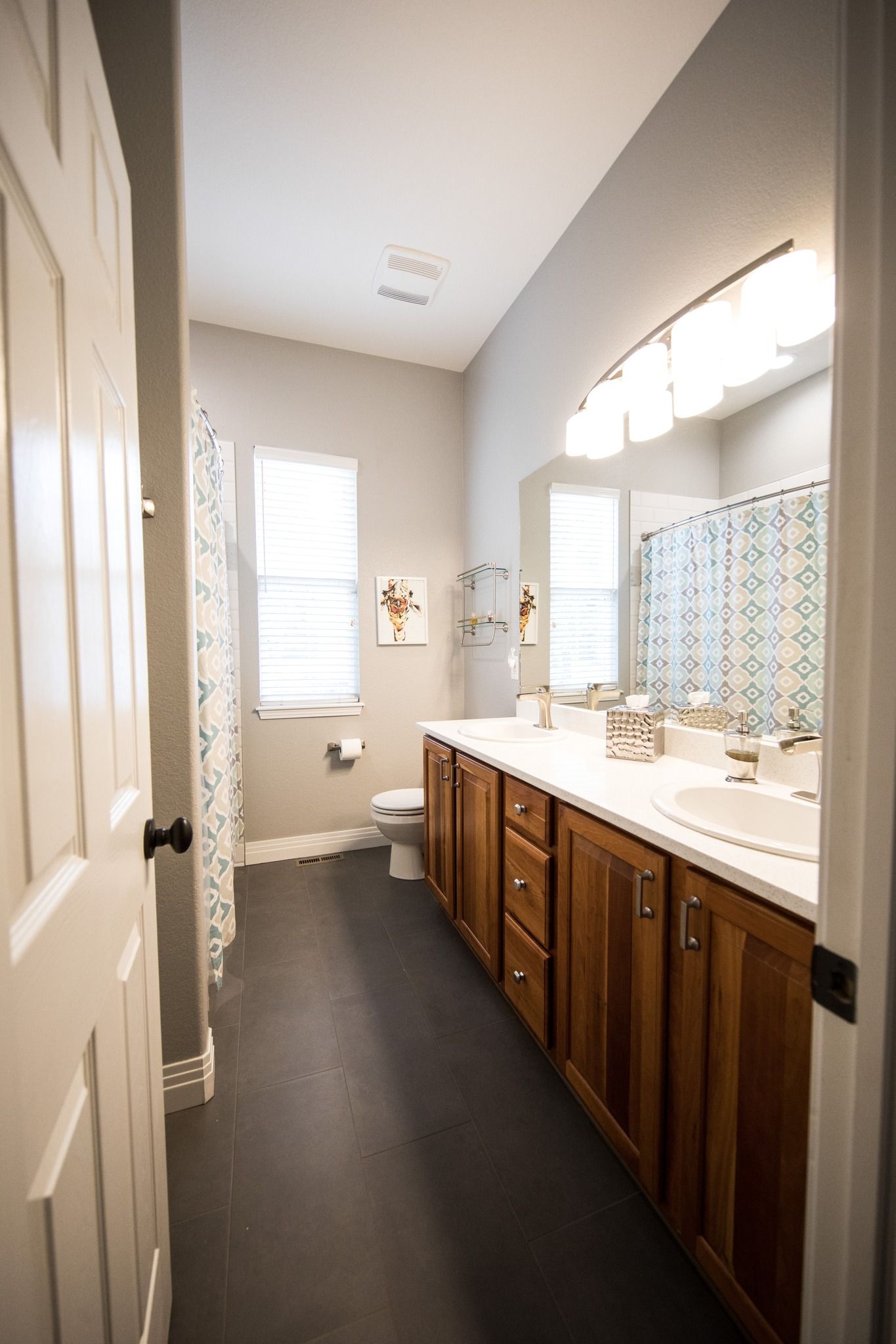 A bathroom with two sinks , a toilet , and a mirror.