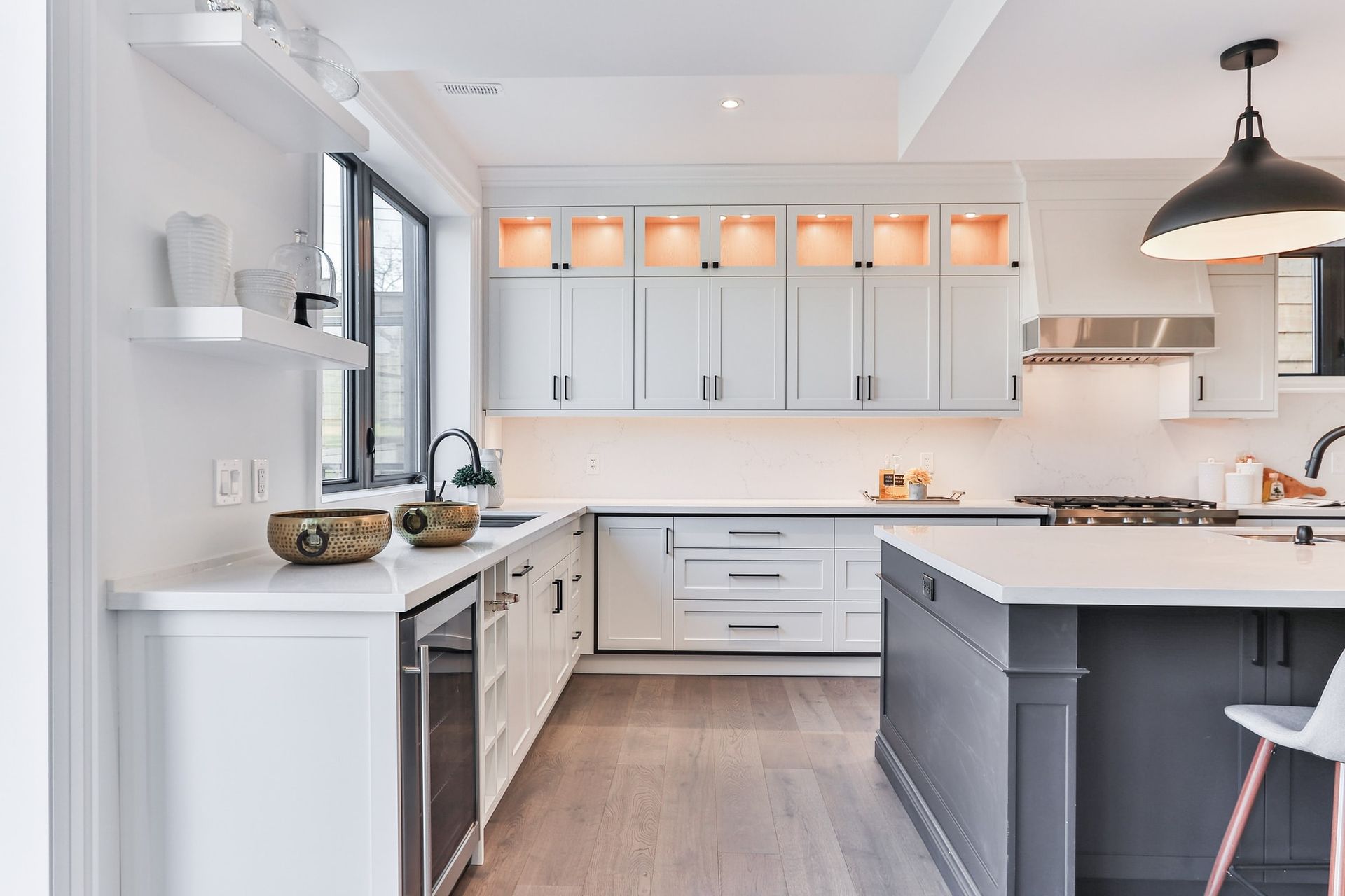 A kitchen with white cabinets , stainless steel appliances , and a large island.
