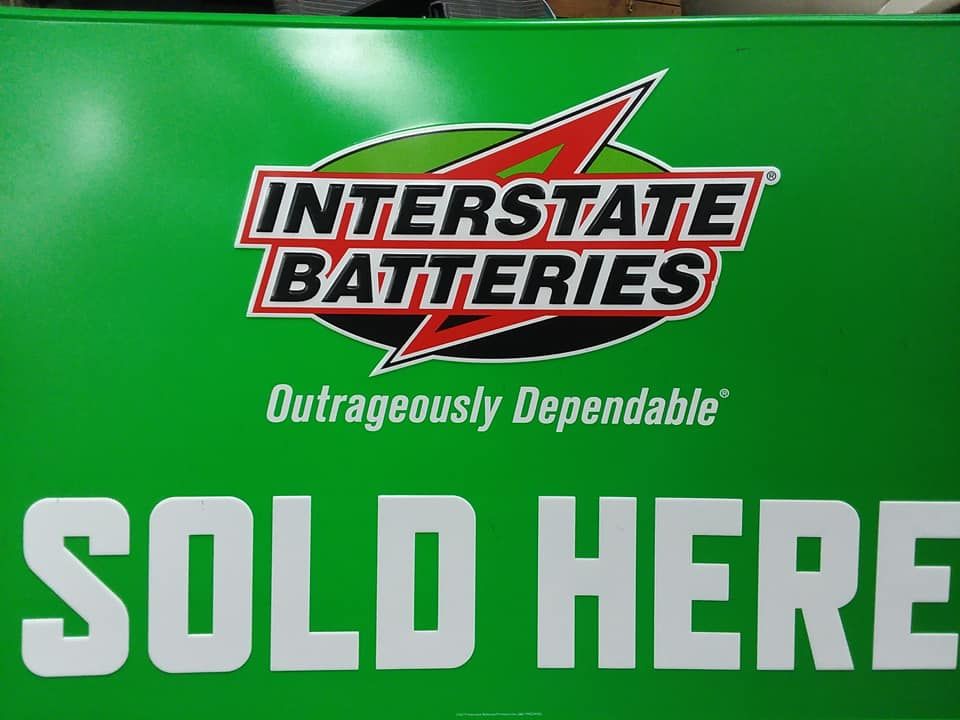 Green sign with Interstate Batteries logo, advertising 