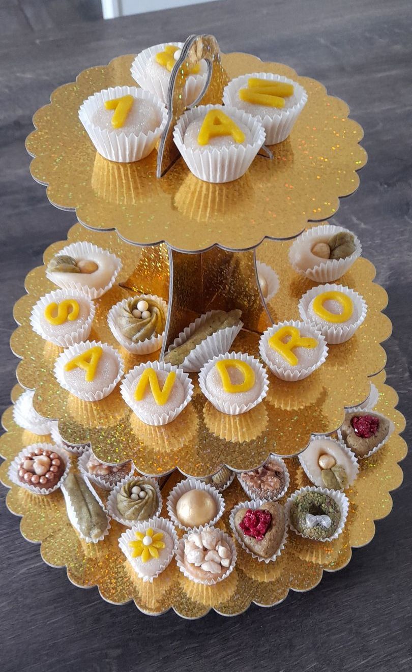Un présentoir à cupcakes rempli de cupcakes et de noix sur une table.