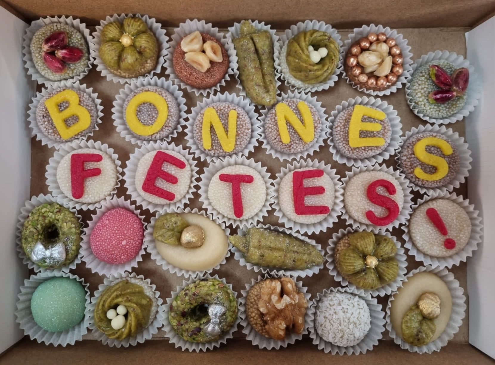 Une boîte de desserts avec les mots « bonnes fêtes » écrits dessus