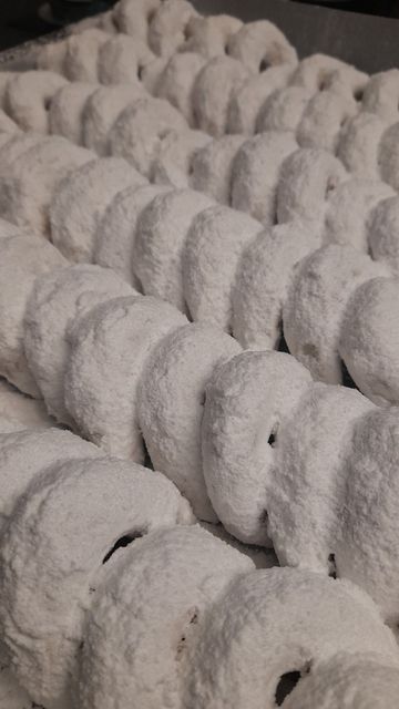 Un tas de beignets recouverts de sucre en poudre sur une table.