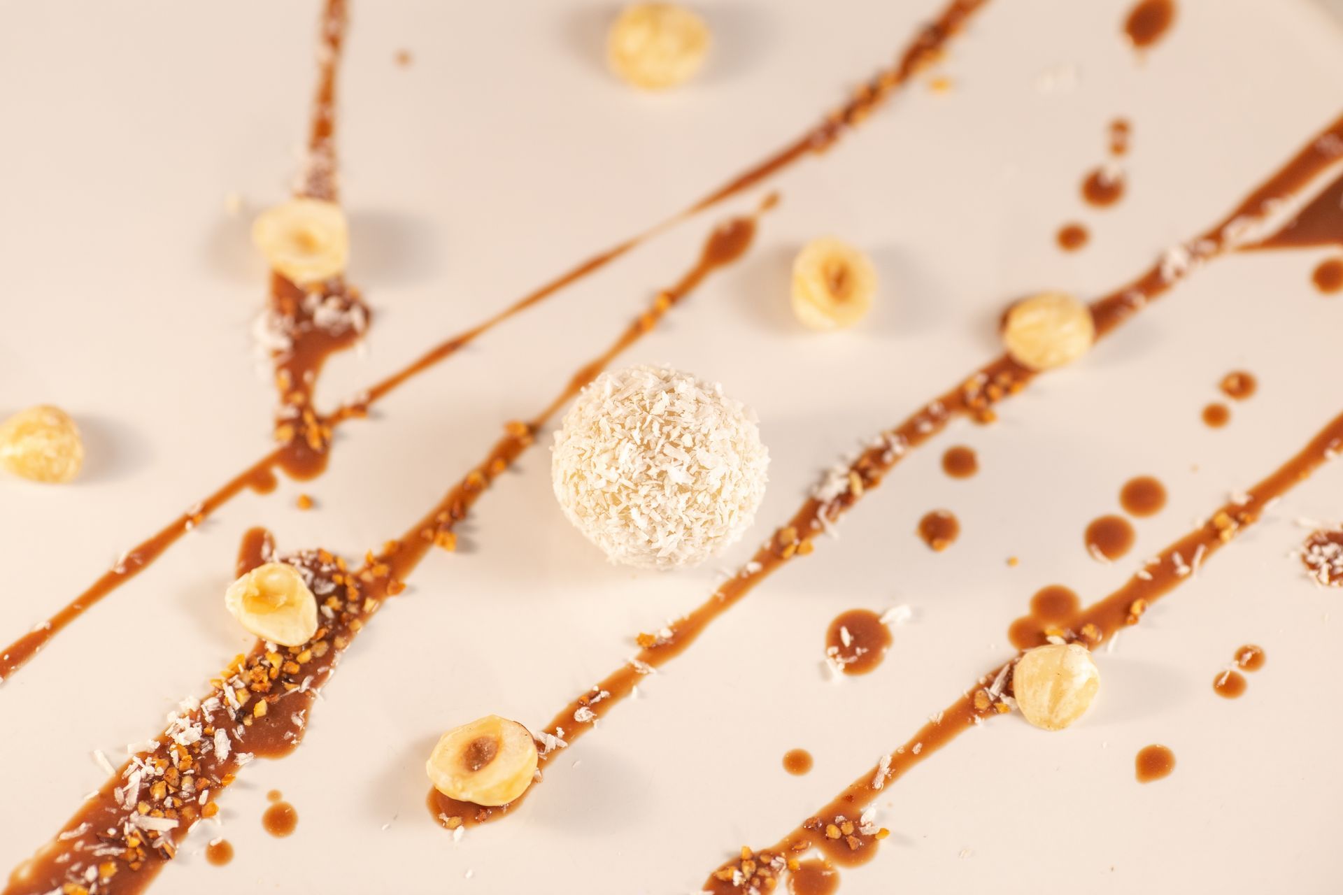 Une assiette blanche garnie de sauce au chocolat et de noix.