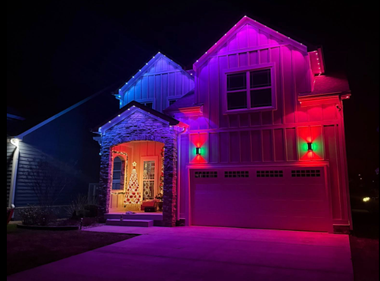 House decorated with colorful purple, pink, and blue lights at night