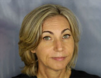 Portrait of a woman with short blonde hair against a gray background