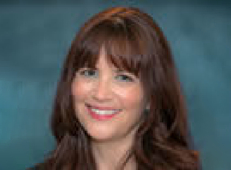 Smiling woman with brown hair against a blue studio backdrop