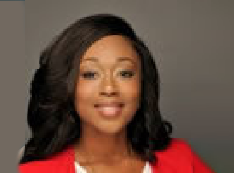 Smiling woman in a red blazer against a gray studio background