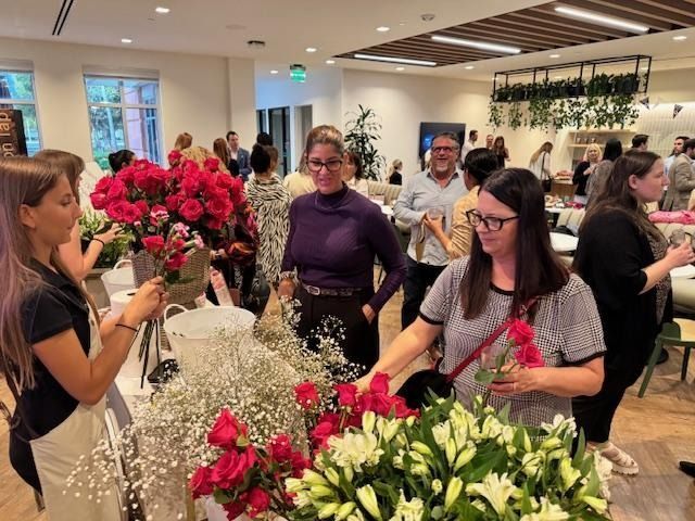People arranging colorful flower bouquets at a lively indoor workshop