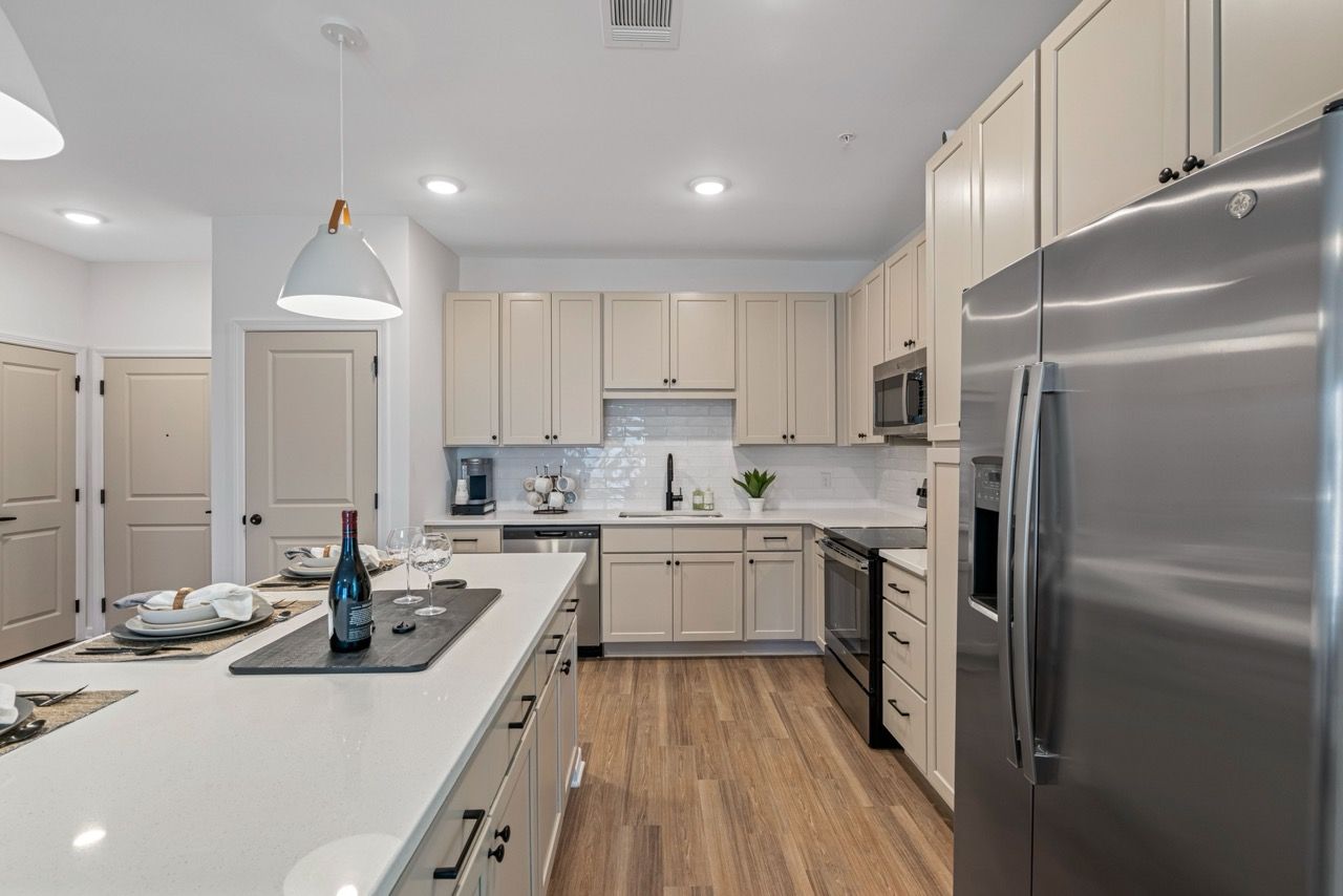 Modern kitchen with white cabinets, stainless steel appliances, and a large island.