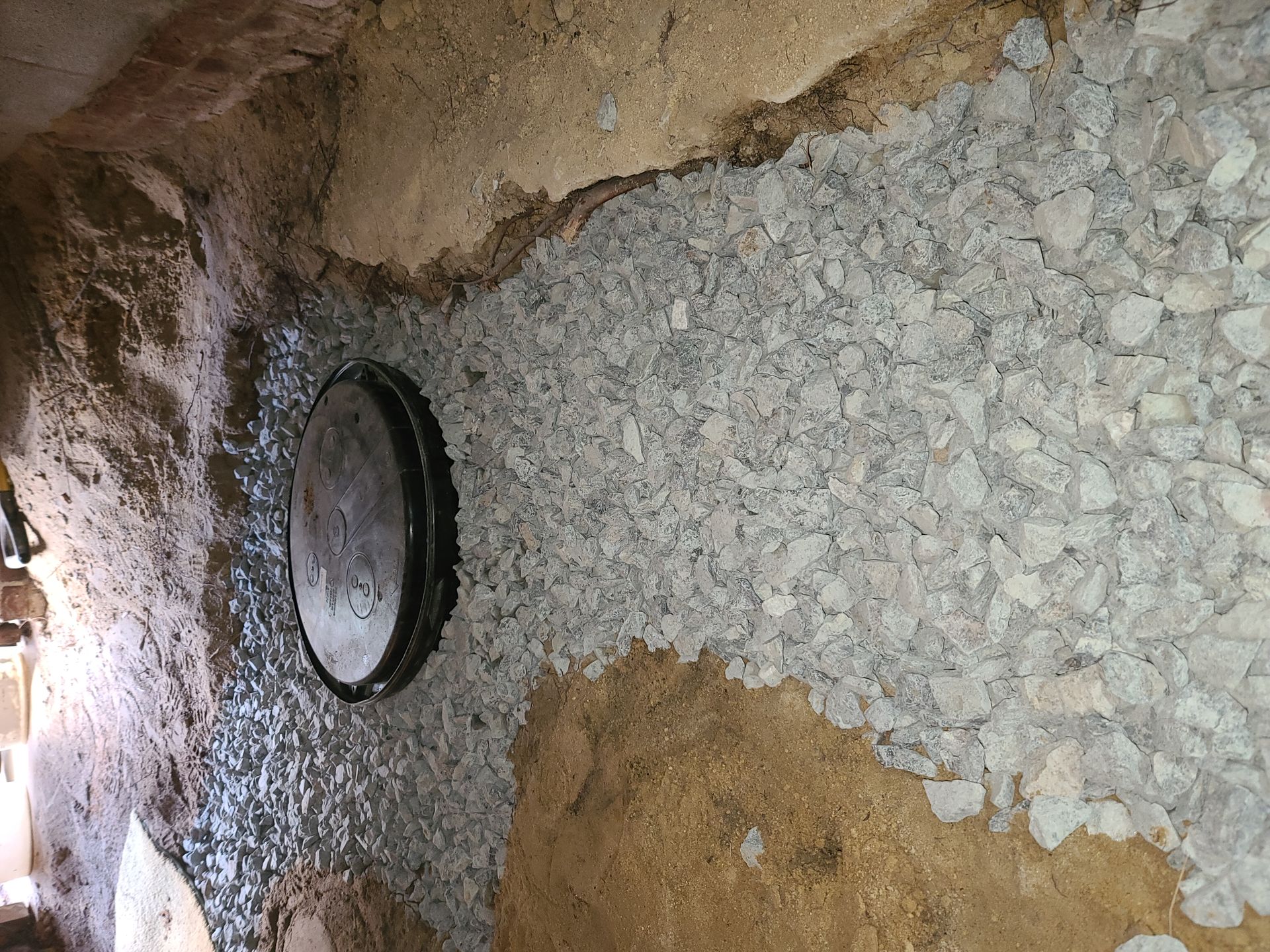 Interior stone wall with a round dark window and rough tan-and-gray textured surfaces