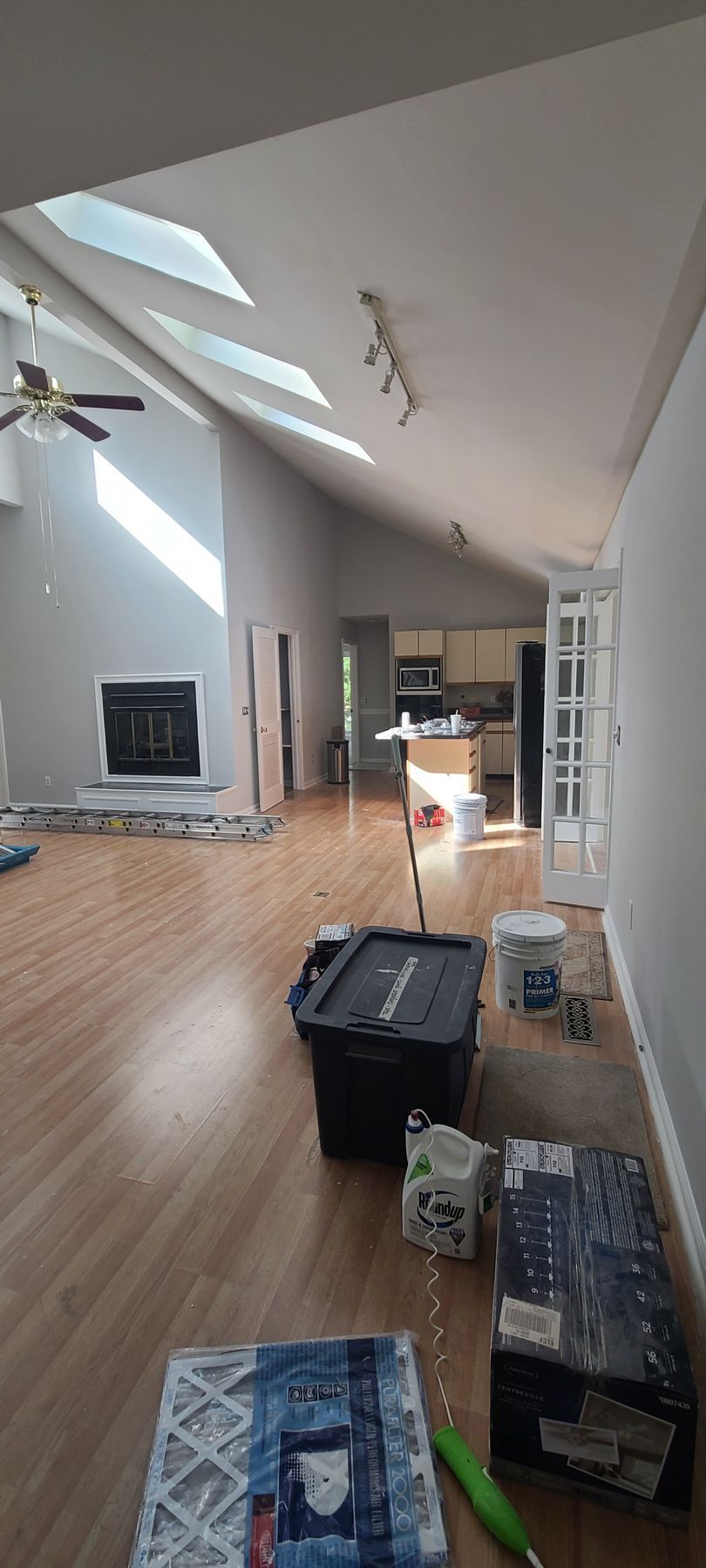 Loft living room with skylight, hardwood floor, TV, and moving boxes on the floor