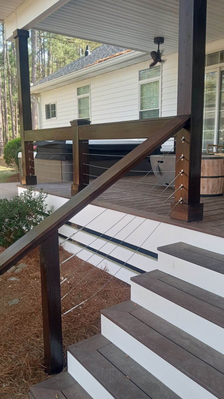 Covered porch with wooden ramp and handrail leading to a house entrance