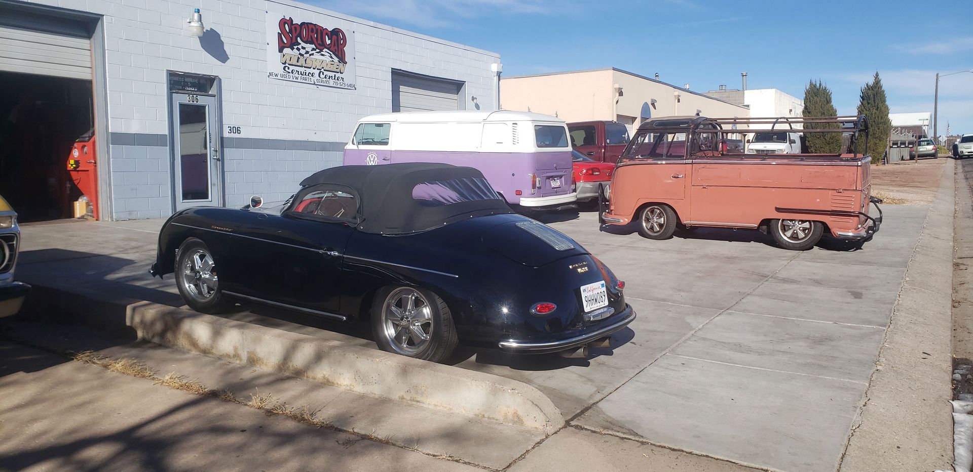 A black sports car is parked in front of a building