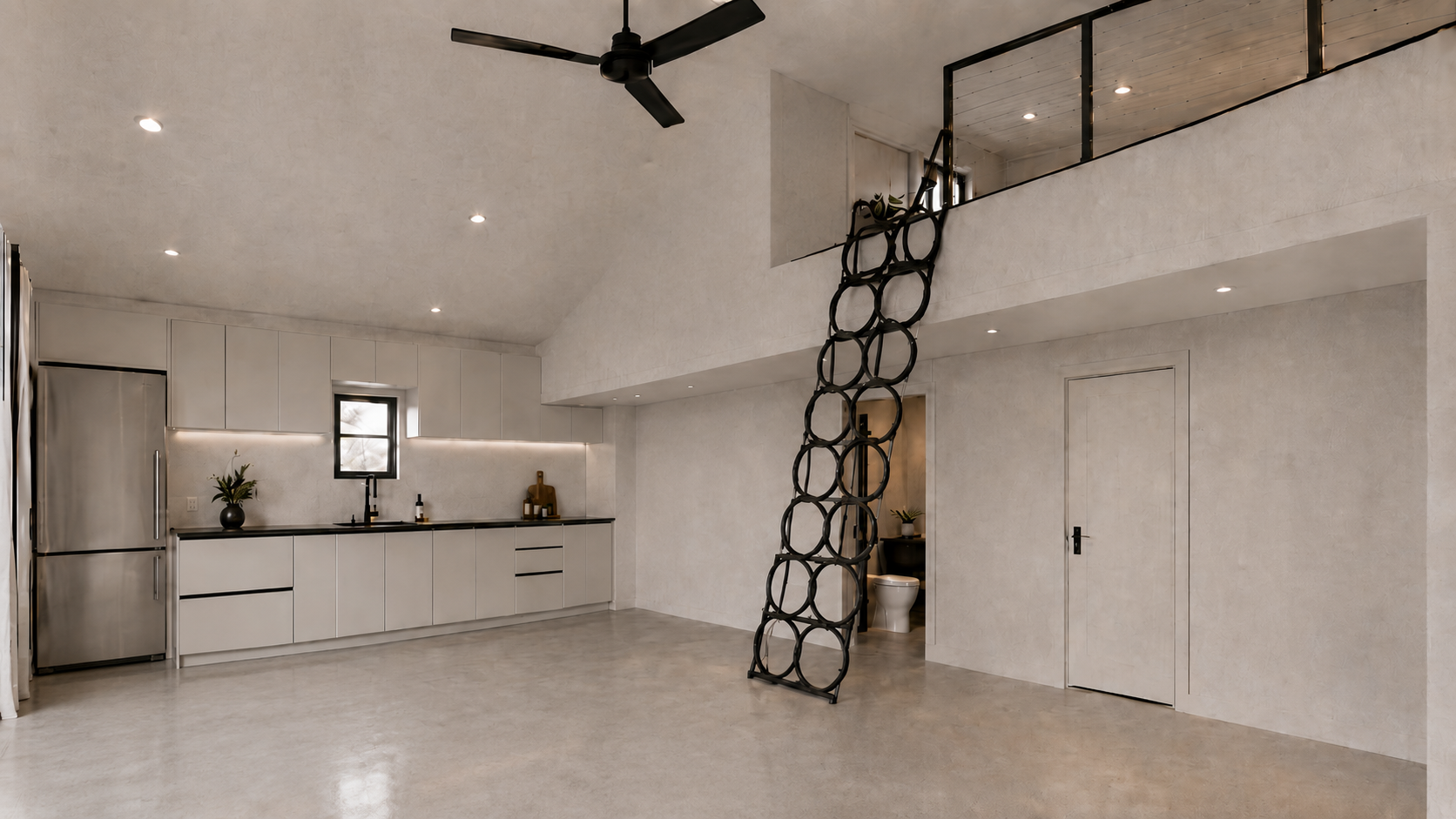 Modern loft interior with white cabinets, loft stairs, ceiling fan, and large open space