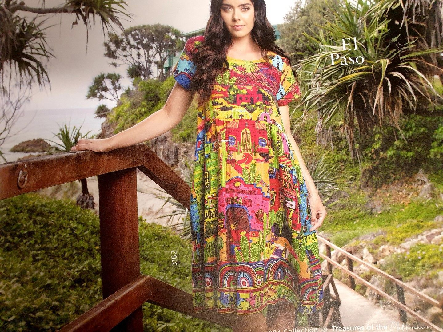 Woman in colorful dress on wooden bridge, outdoors.