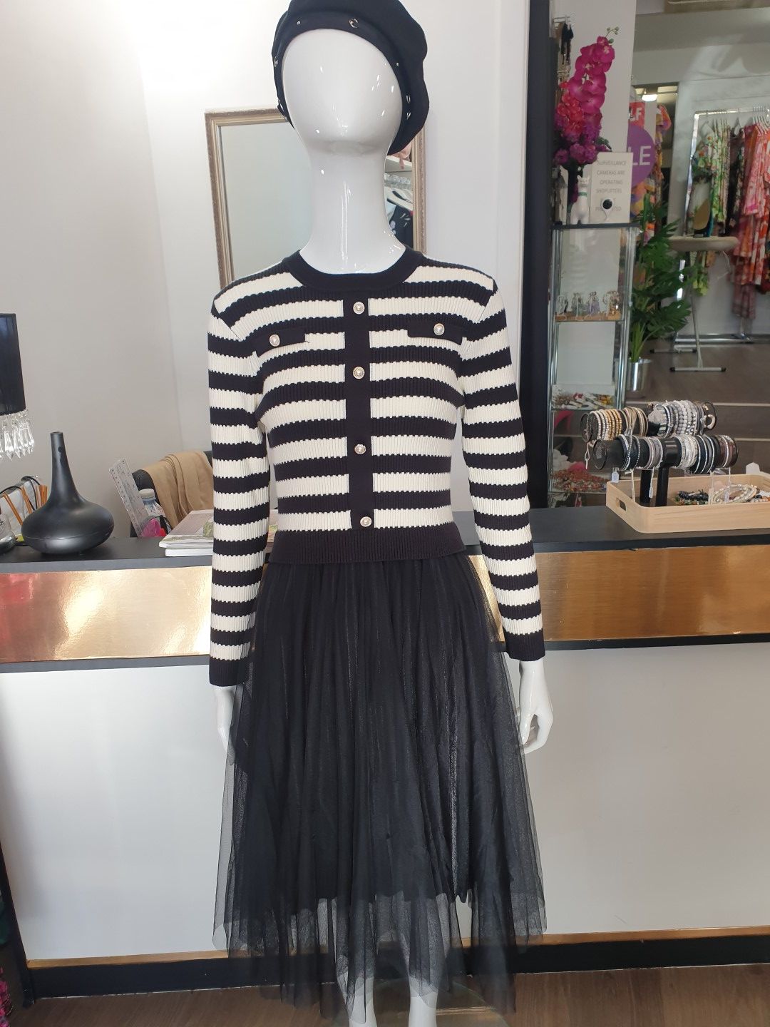 Mannequin in a black and white striped sweater and black tulle skirt, wearing a beret.