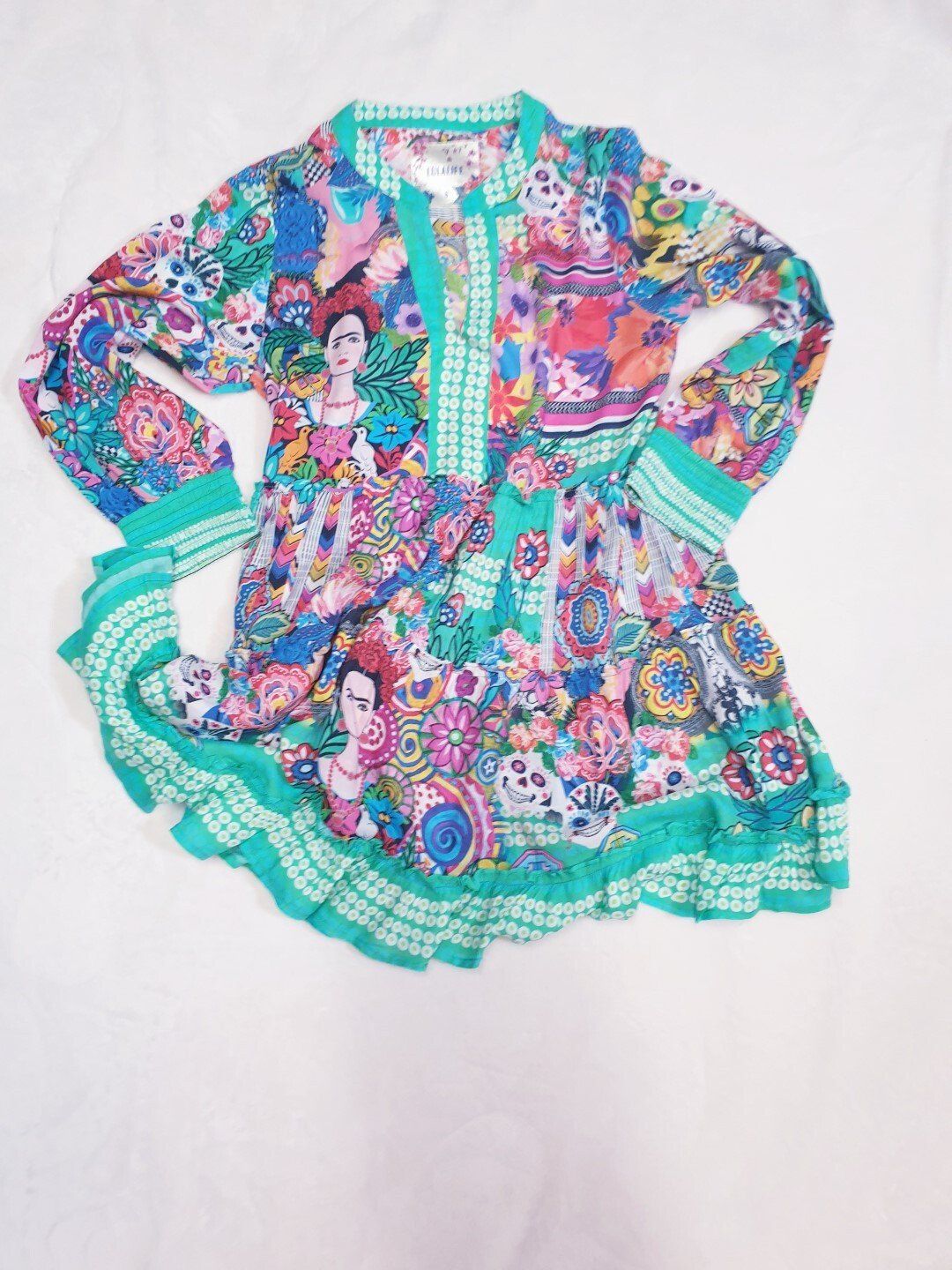 Colorful Frida Kahlo-print long-sleeved dress with turquoise trim and ruffles.