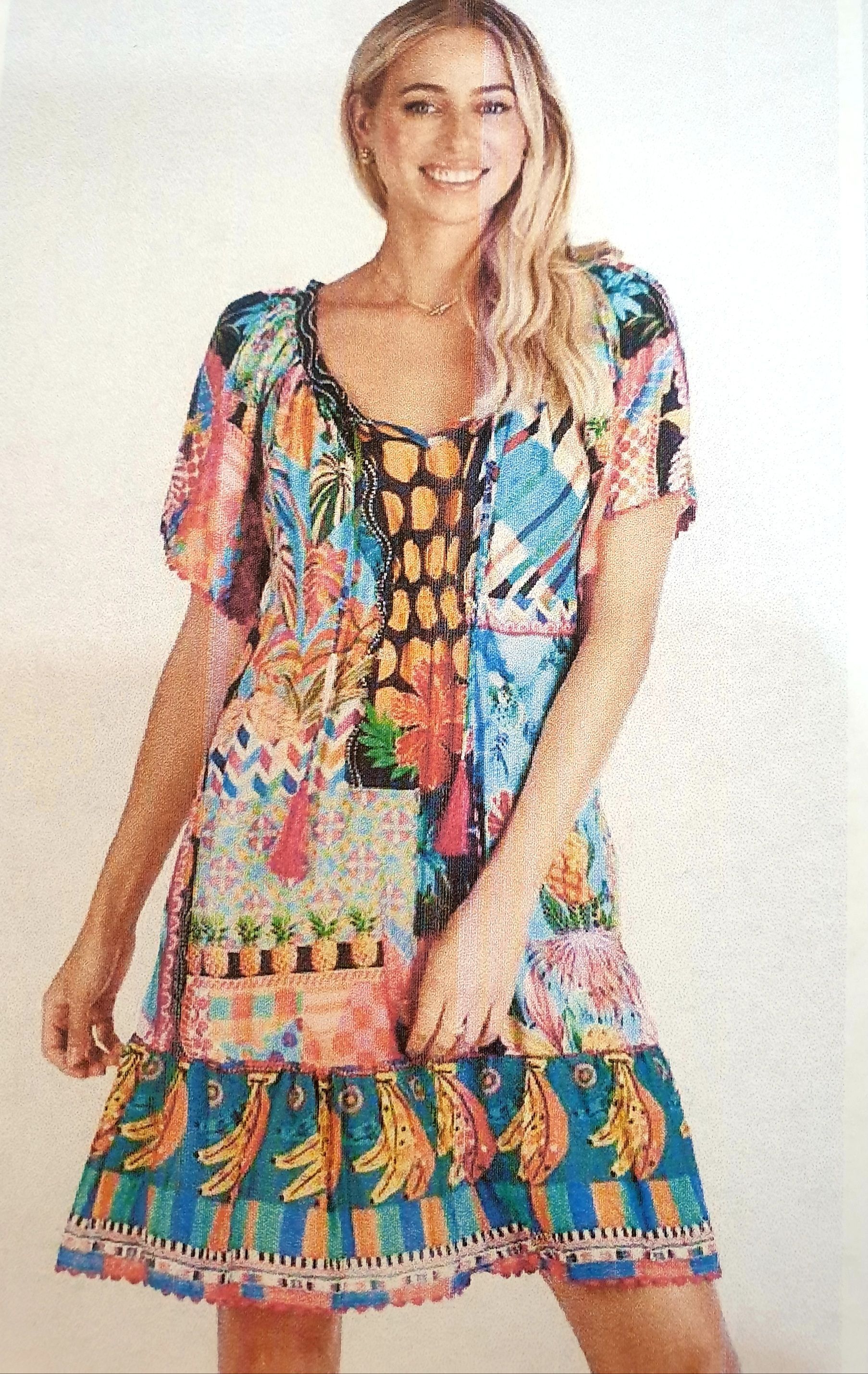 Woman wearing a colorful floral print mini dress, smiling.