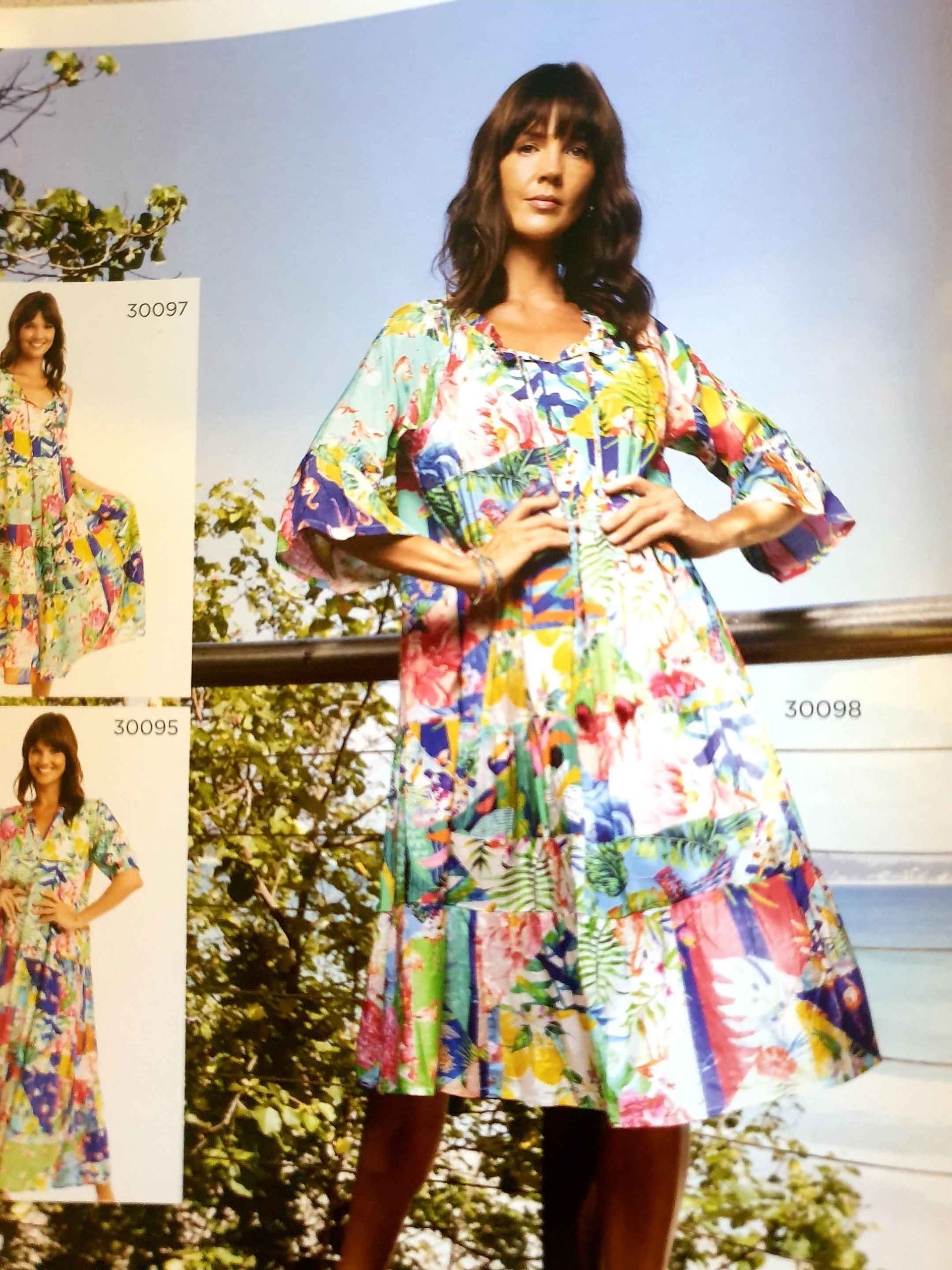 Woman in floral dress, hands on hips, on a balcony. Other dresses in similar patterns shown.