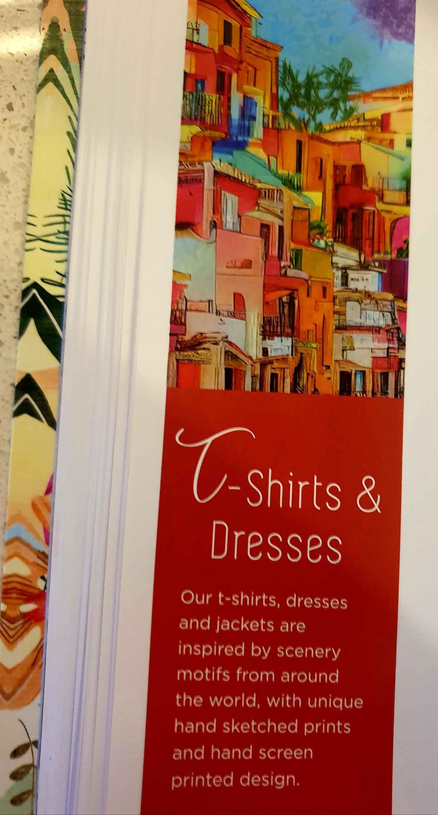 Advertisement for T-shirts and dresses with a colorful cityscape background and text on a red panel.