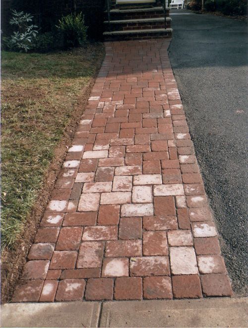 Brick steps leading up to a white door; new concrete work visible with yellow caution tape.