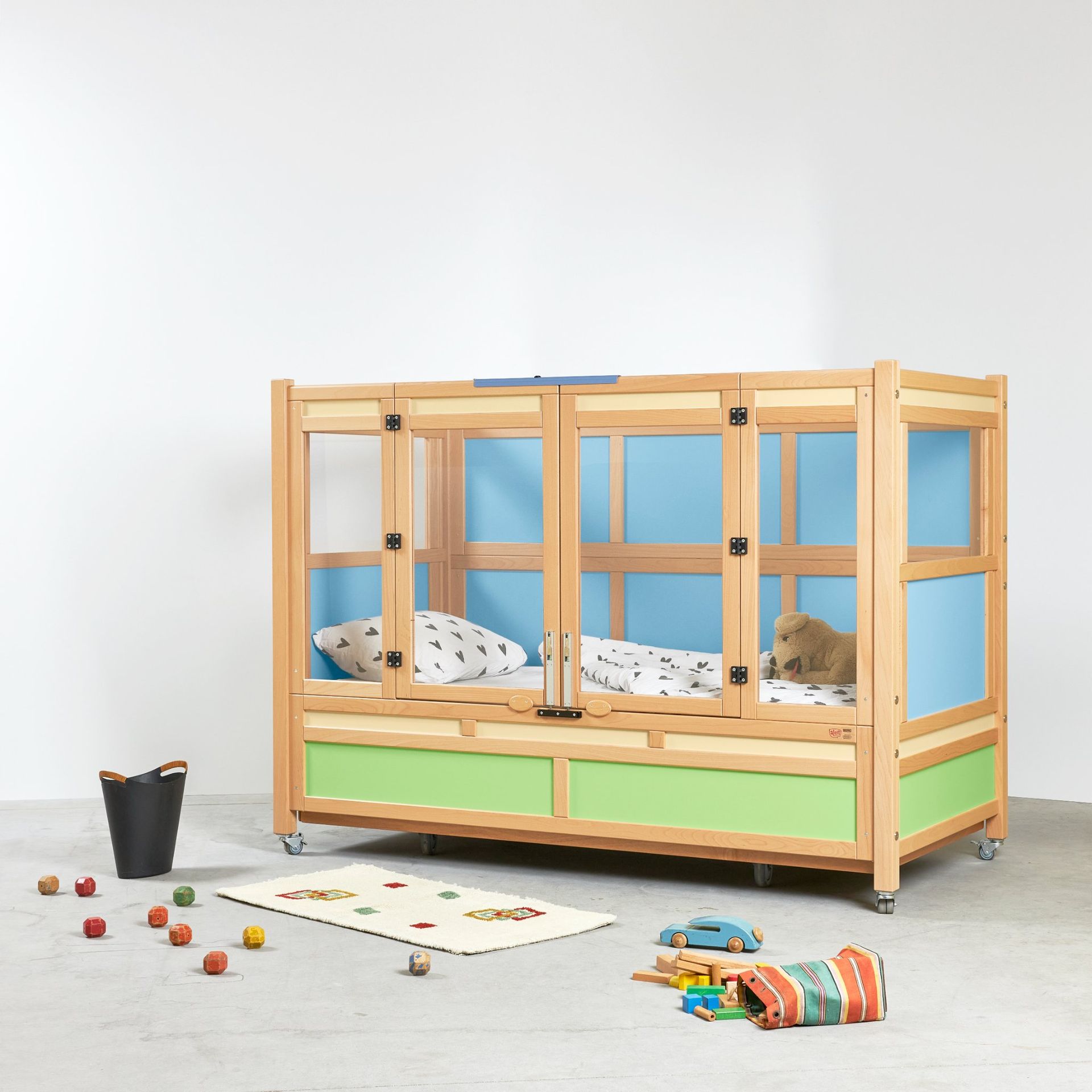 A wooden bed with blue walls and green drawers