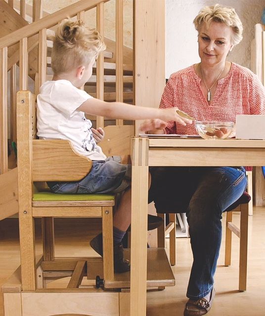 Boy sat at table using BEN Chair with an adult