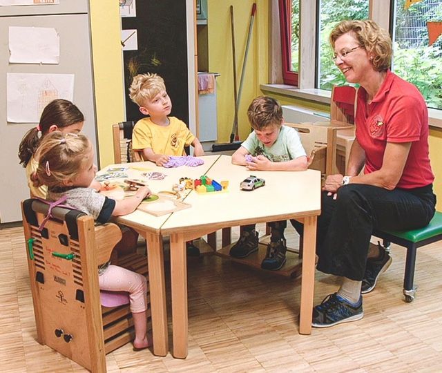 children playing with toys at the table whilst sat in BEN chair