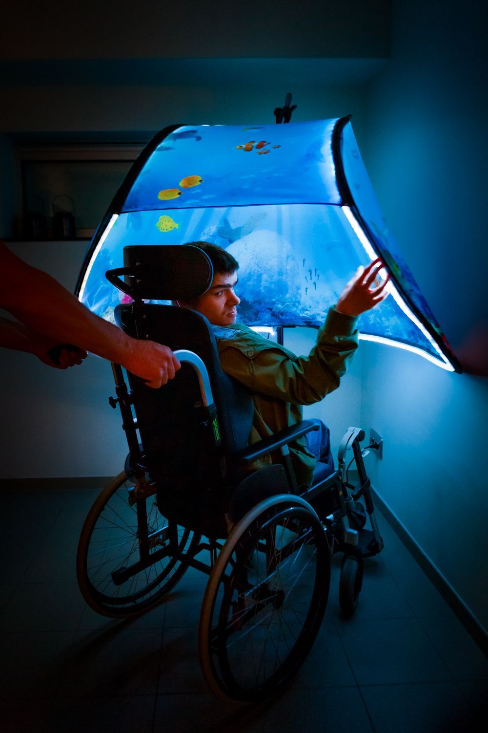 A person in a wheelchair is playing with a lighted Snoezle tent.