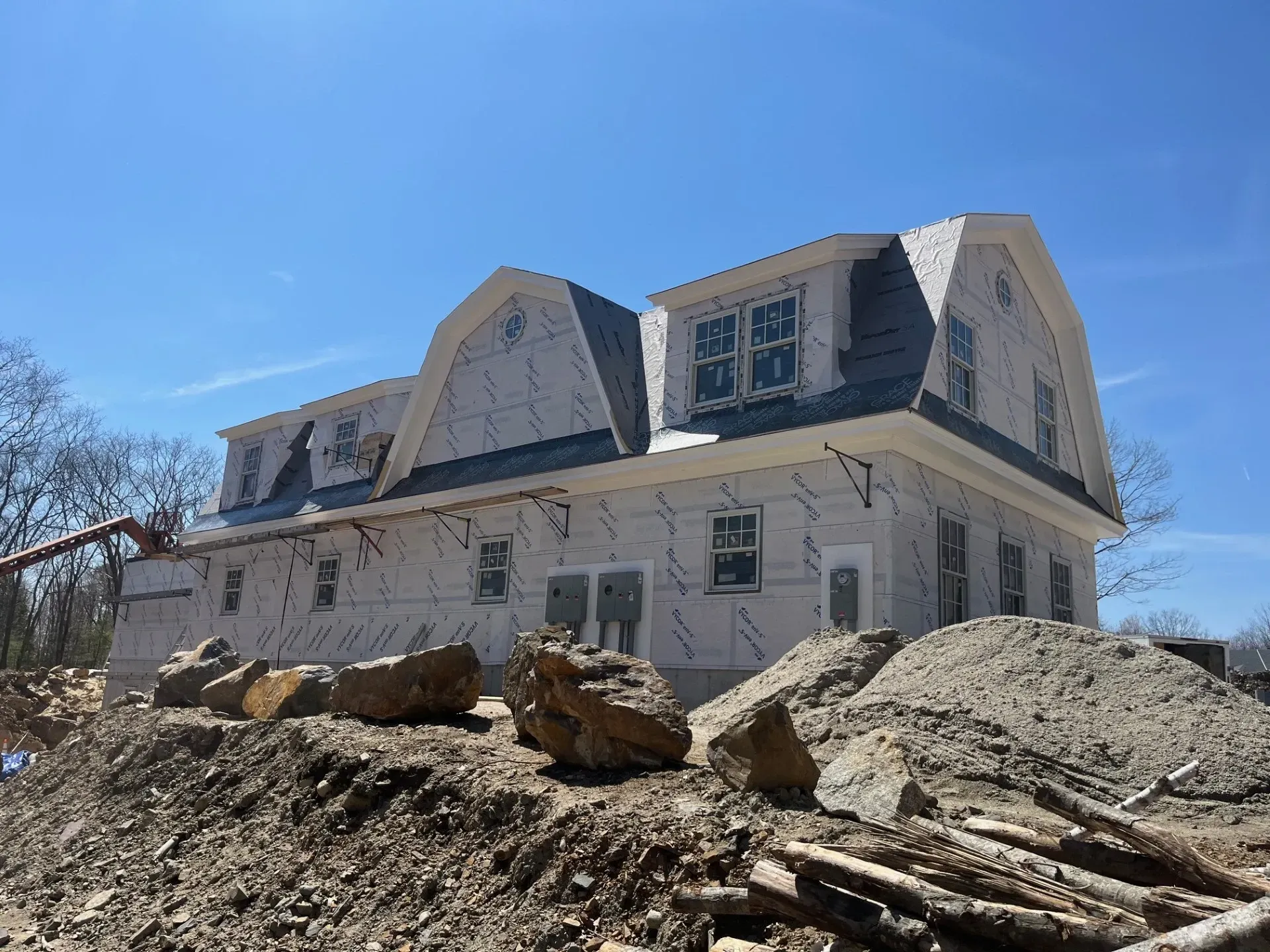 A large white house is being built on top of a pile of rocks.