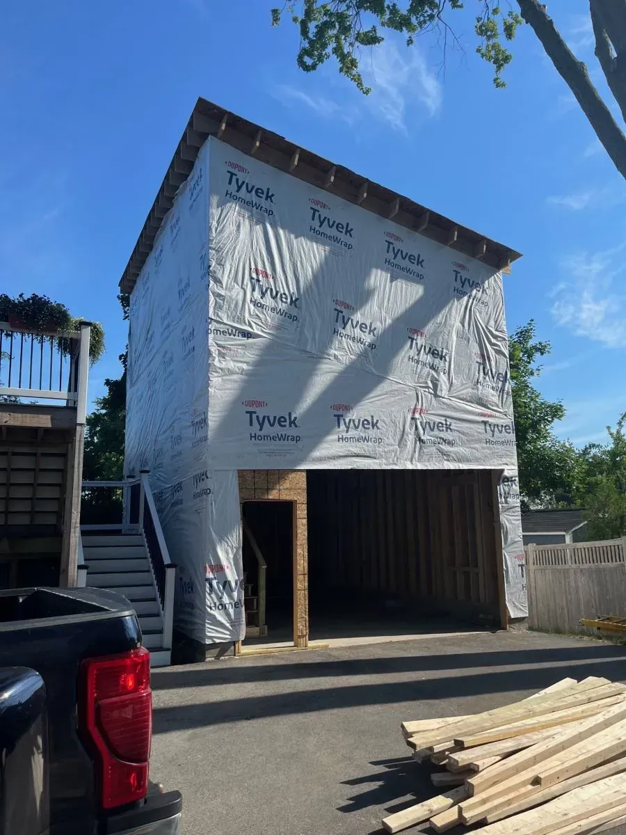 A truck is parked in front of a building that is being built.