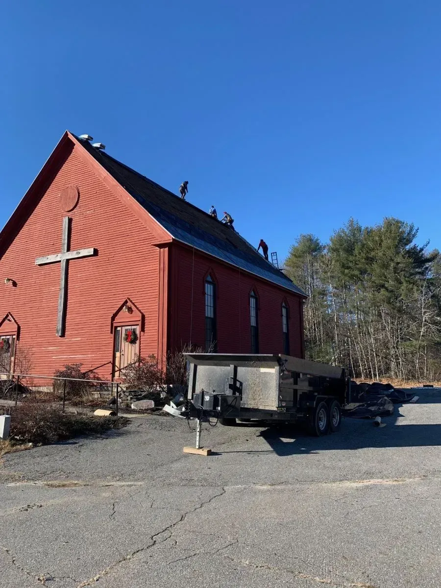 A red barn with a cross on the side of it