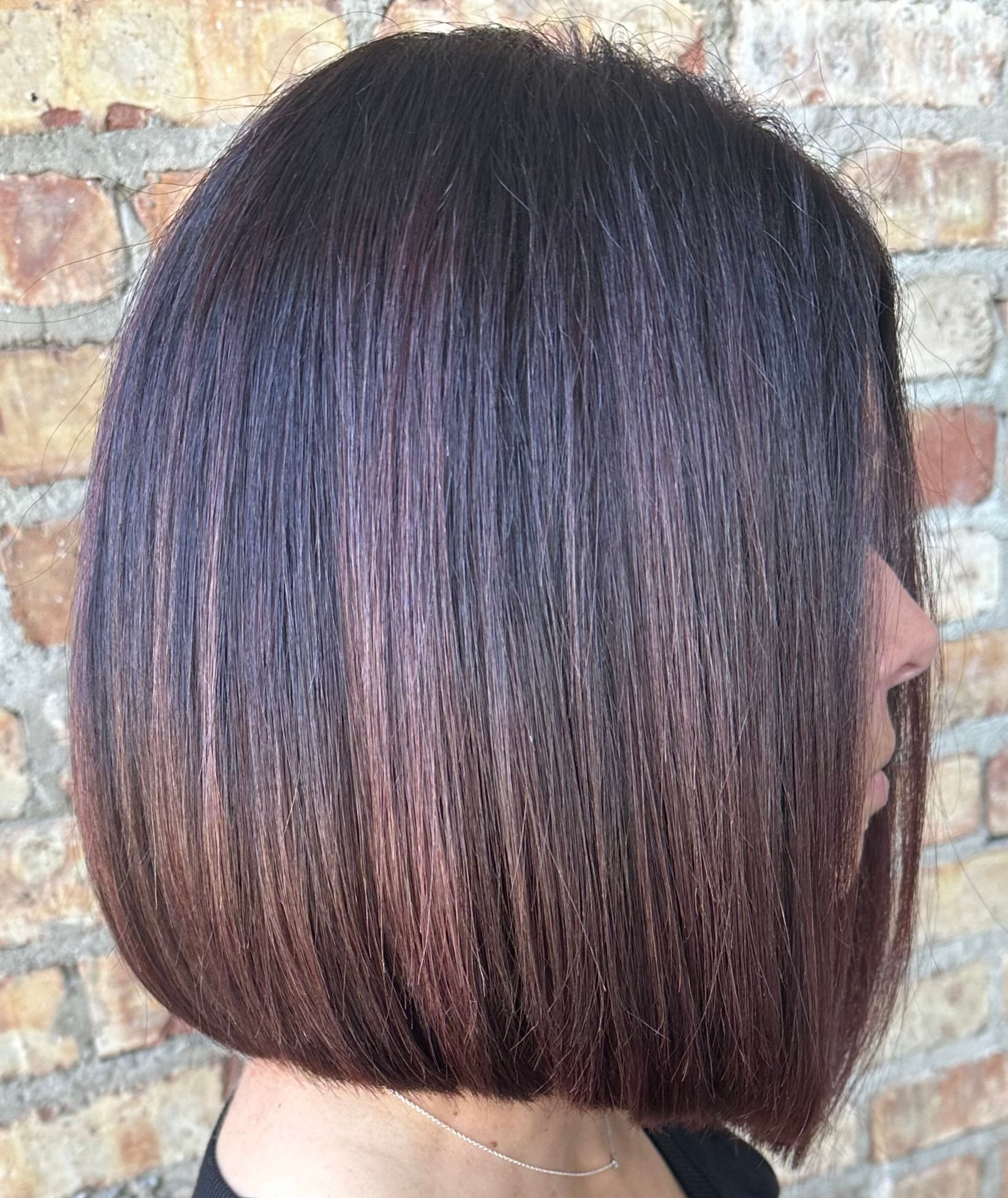 Woman with a straight, dark brown bob hairstyle, possibly highlighted.