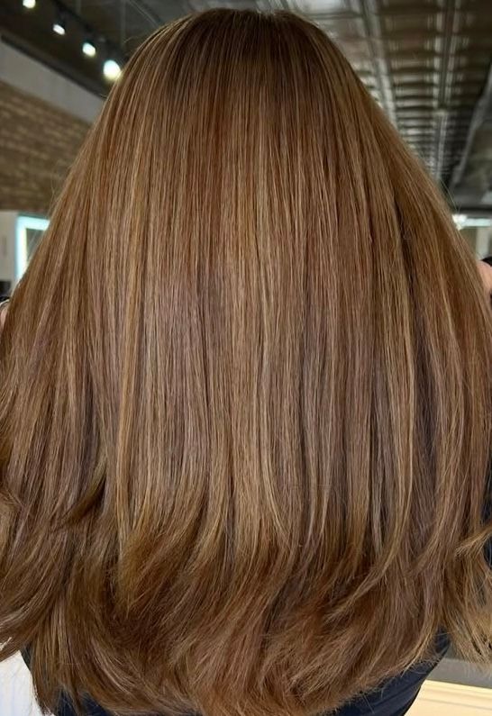 Long brown hair with subtle highlights.