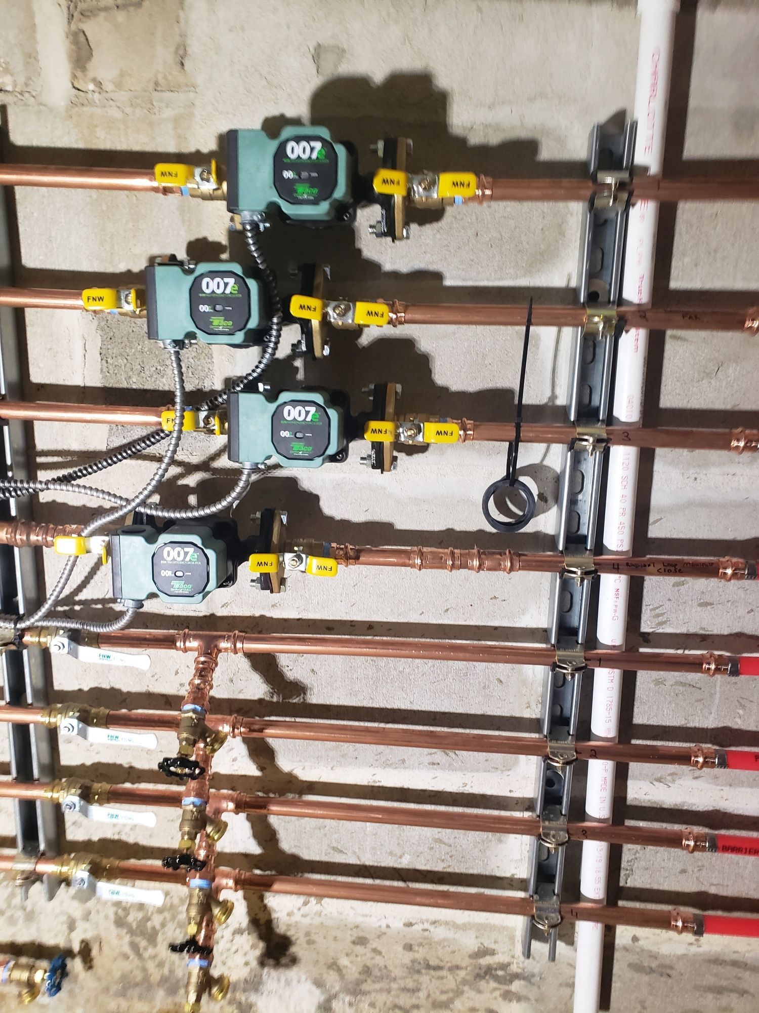 a row of copper pipes with valves attached to them .